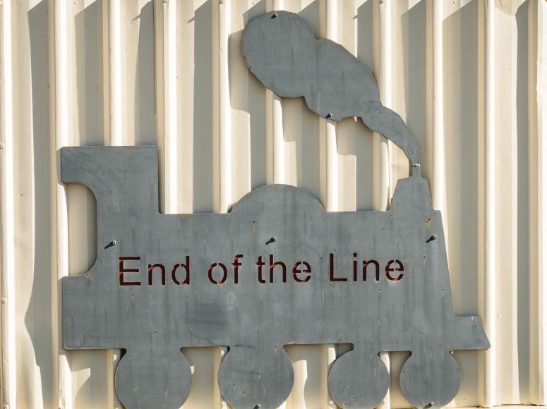 A cut out silhouette of a steam train has the words 'End of the Line' engraved across it.